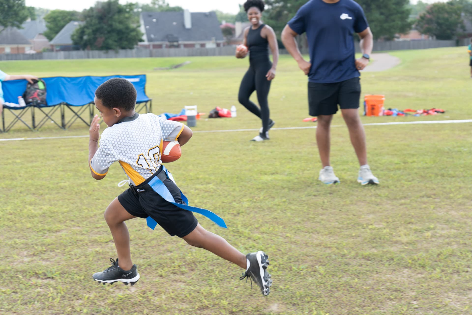 Young flag football player running the ball upfield