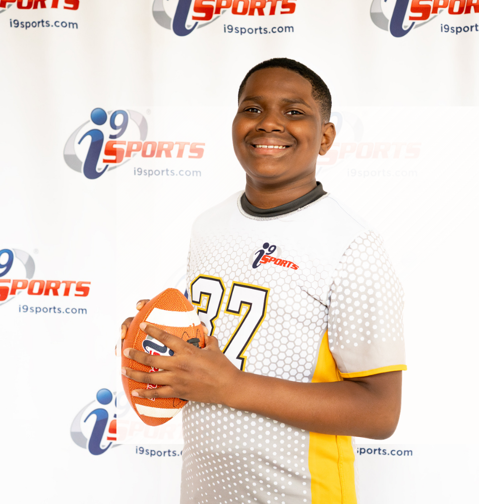 Young i9 Sports athlete holding a football