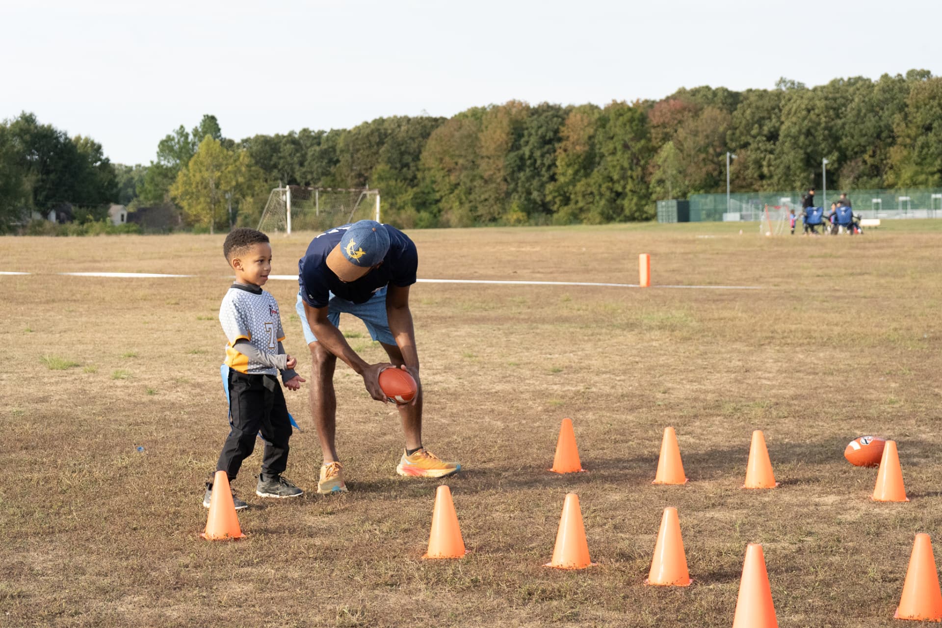 Coach setting up a cone drill with a young player